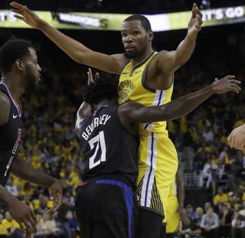 Golden State Warriors forward Kevin Durant, top, is defended by Los Angeles Clippers guard Patrick Beverley (21) during the second half of Game 2 of a first-round NBA basketball playoff series in Oakland, Calif., Monday, April 15, 2019. (AP Photo/Jeff Chiu)