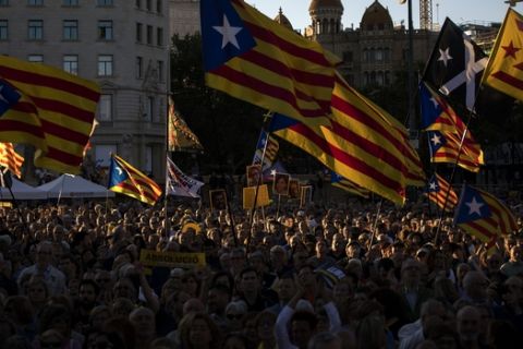 Demonstrators hold independence flags during a protest in downtown Barcelona, Spain, Wednesday, June 12, 2019. Catalan separatist leaders and activists told their Supreme Court trial on Wednesday they were exercising their democratic rights when they held a banned referendum on breaking away from Spain, denying charges of rebellion and sedition. (AP Photo/Emilio Morenatti)