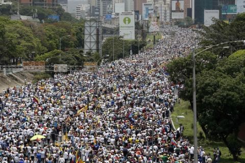 In this April 19, 2017 photo, anti-government protesters march along a highway in Caracas, Venezuela. Opponents of President Nicolas Maduro called on Venezuelans to take to the streets to march against the embattled leader. (AP Photo/Ariana Cubillos)