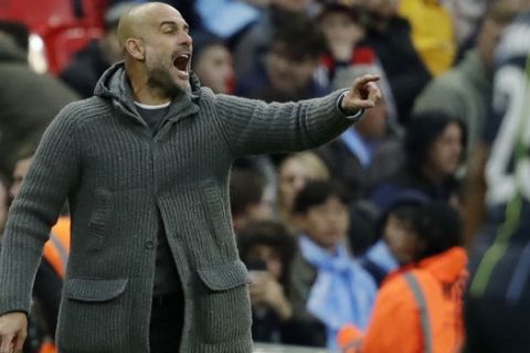 Manchester City coach Pep Guardiola gestures during the English FA Cup semifinal soccer match between Manchester City and Brighton & Hove Albion at Wembley Stadium in London, Saturday, April 6, 2019. (AP Photo/Matt Dunham)