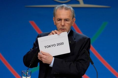 BUENOS AIRES, ARGENTINA - SEPTEMBER 07:  International Olympic Committee (IOC) President Jacques Rogge shows the name of the city of Tokyo elected to host the 2020 Summer Olympics during a session of the IOC in Buenos Aires, on September 7, 2013.   (Photo by Fabrice Coffrini /Pool/Getty Images) ** TCN OUT **