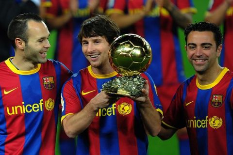 Barcelona's Argentinian forward Lionel Messi (C), flanked with Barcelona's midfielder Xavi Hernandez (R) and Barcelona's midfielder Andres Iniesta (L), poses with the 2010 Ballon d'Or trophy (Golden Ball) for the best European footballer of the year prior to the Copa del Rey (King's Cup) football match FC Barcelona vs Real Betis on January 12, 2011 at the Camp Nou stadium in Barcelona.       AFP PHOTO/ LLUIS GENE (Photo credit should read LLUIS GENE/AFP/Getty Images)