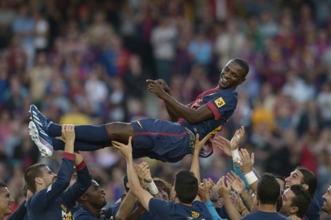 FC Barcelona's Eric Abidal, from France, is thrown into the air by his teammates at the end of the match against Malaga during a Spanish La Liga soccer match at the Camp Nou stadium in Barcelona, Spain, Saturday, June 1, 2013.  Eric Abidal will be leaving Barcelona after six trophy-laden seasons and having fought back from both a liver tumor and a liver transplant to play again. Abidal thanked his teammates, his coaches, and above all the team doctors and physical therapists that helped him through his medical issues. (AP Photo/Manu Fernandez)