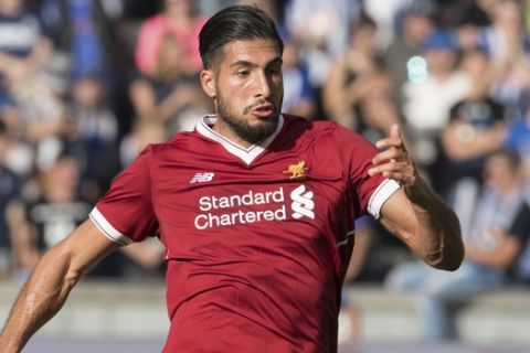 Liverpool's Emre Can, centre, skips past the challenge of Hertha's Per Skjelbred and is pursued by Fabian Lustenberger, left, during the international club friendly soccer match between Hertha BSC and FC Liverpool in the Olympia Stadium in Berlin, Germany, Saturday,  July 29, 2017.  (Soeren Stache/dpa via AP)