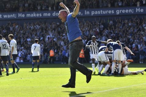 A pitch invader celebrates West Bromwich Albion's first goal of the game,  during the English Premier League soccer match between West Bromwich Albion and Tottenham Hotspur at The Hawthorns, in West Bromwich, England, Saturday May 5, 2018. (Anthony Devlin/PA via AP)