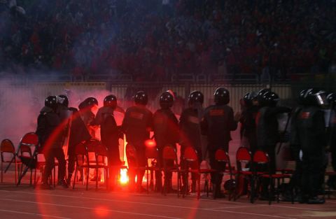 Egyptian riot policemen stand guard as a flare is thrown during a football match between Al-Masry and Al-Ahly in Port Said on February 1, 2012. At least 74 people were killed and hundreds injured when rival fans clashed after the football match, highlighting a security vacuum in post-revolution Egypt. AFP PHOTO/STR (Photo credit should read STR/AFP/Getty Images)