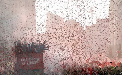 Fans look on as Liverpool soccer team ride an open top bus during the Champions League Cup Winners Parade through the streets of Liverpool, England, Sunday June 2, 2019.  Liverpool is champion of Europe for a sixth time after beating Tottenham 2-0 in the Champions League final played in Madrid Saturday. (Barrington Coombs/PA via AP)