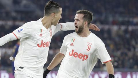Juventus' Cristiano Ronaldo, left, celebrates with teammate Miralem Pjanic after scoring his side's second goal during the Serie A soccer match between Roma and Juventus at the Rome Olympic Stadium, Italy, Sunday, Jan. 12, 2020. (AP Photo/Andrew Medichini)