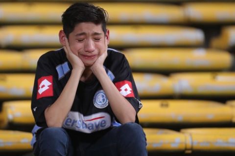 In this Sept. 28, 2016 photo, a fan cries after argentina's Belgrano lost it's match against Brazil's Coritiba during a Copa Sudamericana soccer match in Cordoba, Argentina. (AP Photo/Nicolas Aguilera)