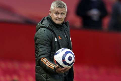 Manchester United's manager Ole Gunnar Solskjaer holds the ball during the English Premier League soccer match between Manchester United and Leicester City, at the Old Trafford stadium in Manchester, England, Tuesday, May 11, 2021. (AP Photo/Dave Thompson, Pool)