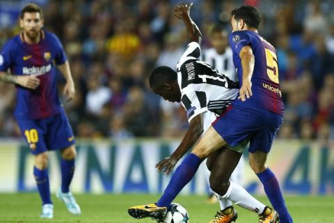Juventus' Blaise Matuidi fights for the ball against Barcelona's Sergio Busquets during a group D Champions League soccer match between FC Barcelona and Juventus at the Camp Nou stadium in Barcelona, Spain, Tuesday, Sept. 12, 2017. (AP Photo/Manu Fernandez)