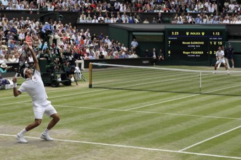Switzerland's Roger Federer, left, serves to Serbia's Novak Djokovic, right, during the men's singles final match of the Wimbledon Tennis Championships in London, Sunday, July 14, 2019. (AP Photo/Ben Curtis)