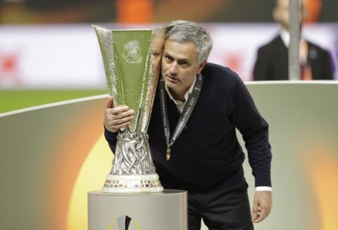 Manchester manager Jose Mourinho poses with the trophy after winning 2-0 during the soccer Europa League final between Ajax Amsterdam and Manchester United at the Friends Arena in Stockholm, Sweden, Wednesday, May 24, 2017. (AP Photo/Michael Sohn)