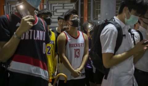A demonstrator wearing a Houston Rockets jersey sings the U.S. national anthem with fellow demonstrators during a rally at the Southorn Playground in Hong Kong, Tuesday, Oct. 15, 2019. Protesters in Hong Kong have thrown basketballs at a photo of LeBron James and chanted their anger about comments the Los Angeles Lakers star made about free speech during a rally in support of NBA commissioner Adam Silver and Houston Rockets general manager Daryl Morey, whose tweet in support of the Hong Kong protests touched off a firestorm of controversy in China. (AP Photo/Mark Schiefelbein)