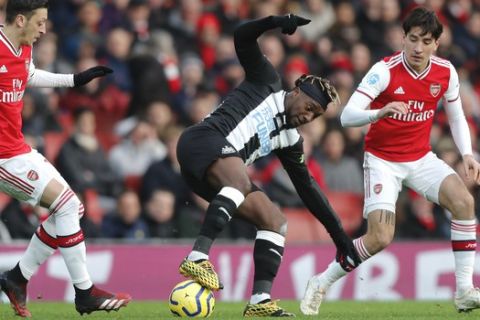 Arsenal's Hector Bellerin, right, challenges for the ball with Newcastle's Allan Saint-Maximin, center, during the English Premier League soccer match between Arsenal and Newcastle at the Emirates Stadium in London, Sunday, Feb. 16, 2020.(AP Photo/Frank Augstein)