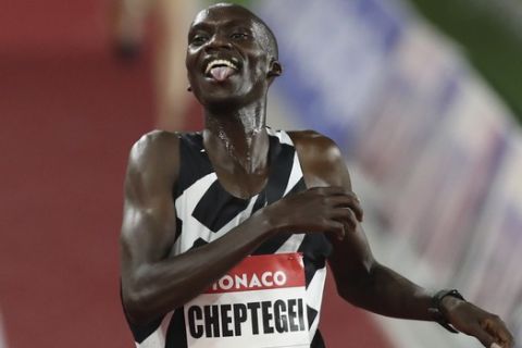 Uganda's Joshua Cheptegei stick his tongue out as he breaks the wold record in the men's 5000 meter final reacts after winning the men's 1500 meter final during the Diamond League athletics meeting in Monaco Friday, Aug. 14, 2020. (AP Photo/Daniel Cole via AP)