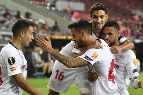 Sevilla's Suso, second from left, celebrates with team mates after scoring his side first goal during the UEFA Europa League semifinal match between FC Sevilla and Manchester United in Cologne, Germany, Sunday, Aug. 16, 2020. (Marius Becker/dpa via AP)