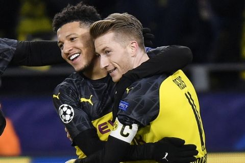 Dortmund's Jadon Sancho, left, is embraced by Dortmund's Marco Reus after scoring the opening goal during the Champions League Group F soccer match between Borussia Dortmund and Slavia Praha in Dortmund, Germany, Tuesday, Dec. 10, 2019. (AP Photo/Martin Meissner)