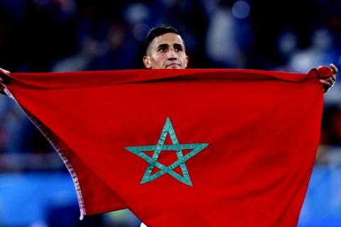 Morocco's Faycal Fajr lifts the national flag after the group B match between Spain and Morocco at the 2018 soccer World Cup at the Kaliningrad Stadium in Kaliningrad, Russia, Monday, June 25, 2018. (AP Photo/Manu Fernandez)