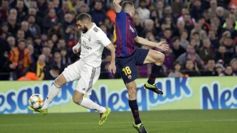 Real forward Karim Benzema, left, gives the pass that leads to his team scoring their side's first goal as Barcelona defender Jordi Alba, fails to stop the pass during the Copa del Rey semifinal first leg soccer match between FC Barcelona and Real Madrid at the Camp Nou stadium in Barcelona, Spain, Wednesday Feb. 6, 2019. (AP Photo/Emilio Morenatti)