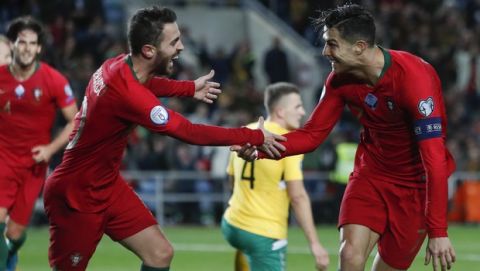Portugal's Cristiano Ronaldo, right, celebrates with teammate Bernardo Silva after scoring their side's sixth goal during the Euro 2020 group B qualifying soccer match between Portugal and Lithuania at the Algarve stadium outside Faro, Portugal, Thursday, Nov. 14, 2019. (AP Photo/Armando Franca)