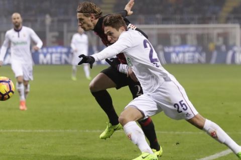 Fiorentina's Federico Chiesa, right, and AC Milan's Ignazio Abate go for the ball during a Serie A soccer match at the San Siro stadium in Milan, Italy, Sunday, Feb. 19, 2017. (AP Photo/Antonio Calanni)