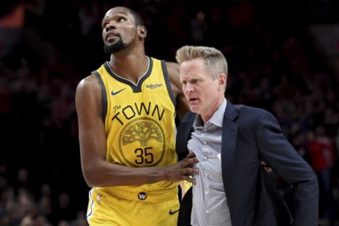 Golden State Warriors forward Kevin Durant, left, helps escort coach Steve Kerr after Kerr was ejected during the second half of the team's NBA basketball game against the Portland Trail Blazers in Portland, Ore., Wednesday, Feb. 13, 2019. The Blazers won 129-107. (AP Photo/Steve Dykes)