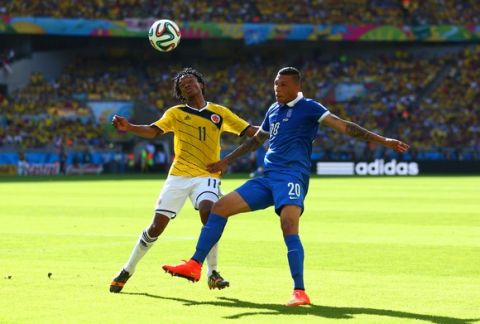 BELO HORIZONTE, BRAZIL - JUNE 14:  Juan Guillermo Cuadrado of Colombia and Jose Cholevas of Greece fight for the ball during the 2014 FIFA World Cup Brazil Group C match between Colombia and Greece at Estadio Mineirao on June 14, 2014 in Belo Horizonte, Brazil.  (Photo by Jeff Gross/Getty Images)