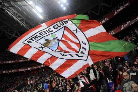 Athletic Bilbao's supporters wave their team flag during their Spanish League soccer match against Real Madrid, at San Mames stadium in Bilbao, Spain, Sunday, Feb. 2, 2014. (AP Photo/Alvaro Barrientos)