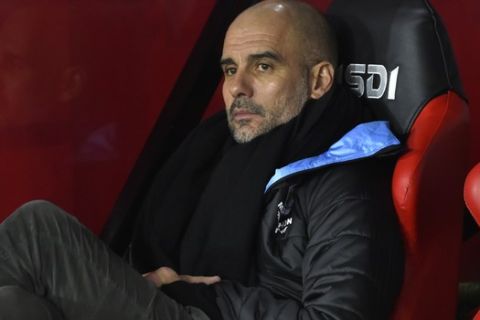 Manchester City's head coach Pep Guardiola looks out from the bench prior the English Premier League soccer match between Sheffield United and Manchester City at Bramall Lane in Sheffield, England, Tuesday, Jan. 21, 2020. (AP Photo/Rui Vieira)