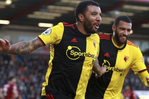 Watford's Troy Deeney. left, scores his side's second goal of the game against Bournemouth, during their English Premier League soccer match at the Vitality Stadium in Bournemouth, England, Sunday, Jan. 12, 2020. (Adam Davy/PA via AP)