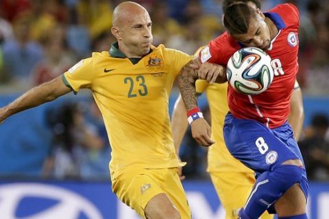 Australia's Mark Bresciano, left, and Chile's Arturo Vidal battle for the ball during the group B World Cup soccer match between Chile and Australia at the Arena Pantanal in Cuiaba, Brazil, Friday, June 13, 2014. (AP Photo/Felipe Dana)