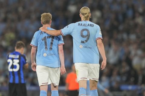 Manchester City's Erling Haaland, right, comforts his teammate Kevin De Bruyne after he got injured and had to be substituted by Manchester City's Phil Foden during the Champions League final soccer match between Manchester City and Inter Milan at the Ataturk Olympic Stadium in Istanbul, Turkey, Saturday, June 10, 2023. (AP Photo/Antonio Calanni)