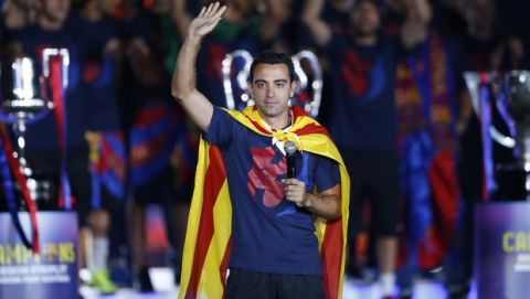 Barcelona's Xavi Hernandez waves to the fans during celebrations at the Camp Nou stadium in Barcelona, Spain Sunday June 7, 2015 after winning the Champions League final soccer match Saturday by beating Juventus Turin 3-1. Barcelona won the triple this season winning the Spanish League title, the Copa del Rey and the Champions League. (AP Photo/Manu Fernandez)  