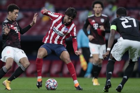 Ο Ζοάο Φέλιξ προσπαθεί να ξεφύγει από δύο παίκτες κατά τη διάρκεια του Ατλέτικο Μαδρίτης - Μπάγερν για το Champions League