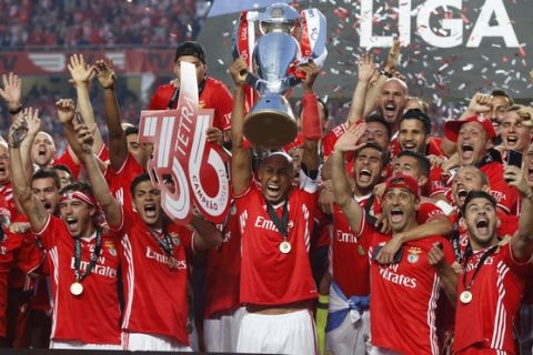Benfica's team captain Luisao lifts the Portuguese league trophy at the end of the soccer match between Benfica and Vitoria de Guimaraes at the Luz stadium in Lisbon, Saturday, May 13, 2017. Benfica won the match 5-0 to clinch the championship title with one round left to play. (AP Photo/Pedro Rocha)