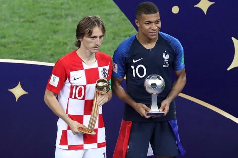 Croatia's Luka Modric and France's Kylian Mbappe, right, pose with their individual awards at the end of the final match between France and Croatia at the 2018 soccer World Cup in the Luzhniki Stadium in Moscow, Russia, Sunday, July 15, 2018. (AP Photo/Thanassis Stavrakis)