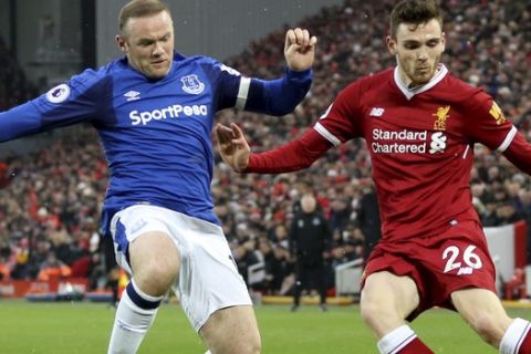 Everton's Wayne Rooney, left, and Liverpool's Andrew Robertson battle for the ball during their English Premier League soccer match at Anfield, Liverpool, England, Sunday, Dec. 10, 2017. (Peter Byrne/PA via AP)