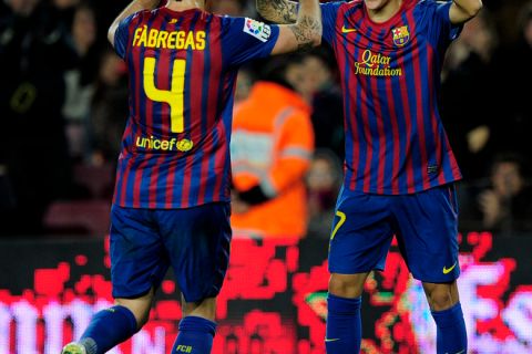 Barcelona's forward Tello (R) is congratuled by his team mate midfielder Cesc Fabregas (L) after scoring a goal during a Spanish Cup football match FC Barcelona vs Hospitalet on December 22, 2011 at the Camp Nou stadium in Barcelona.    AFP PHOTO/ JOSEP LAGO (Photo credit should read JOSEP LAGO/AFP/Getty Images)