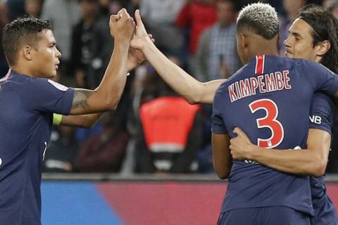 PSG's Thiago Silva, left, and PSG's Presnel Kimpembe, second right, celebrate with teammate Edinson Cavani, right, who scored their side's second goal during their French League One soccer match between Paris-Saint-Germain and Saint-Etienne at the Parc des Princes stadium in Paris, Friday, Sept. 14, 2018. (AP Photo/Michel Euler)