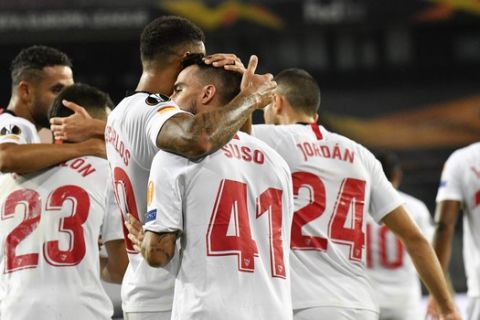 Sevilla players celebrate after their teammate Suso scored their side's first goal during an Europa League semifinal match between Sevilla and Manchester United, in Cologne, Germany, Sunday, Aug. 16, 2020. (AP Photo/Martin Meissner, Pool)