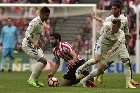 Real Madrid's Toni KrooS, right, duels for the ball with Athletic Bilbao's Raul Garcia during the Spanish La Liga soccer match between Real Madrid and Athletic Bilbao, at San Mames stadium, in Bilbao, northern Spain, Saturday, March 18, 2017. (AP Photo/Alvaro Barrientos)