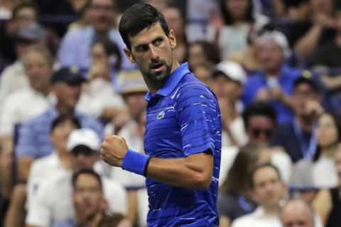 Novak Djokovic, of Serbia, pumps his fist as he looks back toward his coach after winning a point against Denis Kudla during the third round of the U.S. Open tennis tournament Friday, Aug. 30, 2019, in New York. (AP Photo/Charles Krupa)