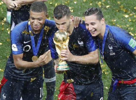 France's Kylian Mbappe, Lucas Hernandez, Florian Thauvin hold the trophy after the final match between France and Croatia at the 2018 soccer World Cup in the Luzhniki Stadium in Moscow, Russia, Sunday, July 15, 2018. (AP Photo/Frank Augstein)