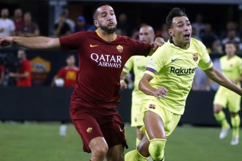 Roma defender Konstantinos Manolas, left, puts a hand to the back of Barcelona forward Munir el Haddadi (9) during the first half of an International Champions Cup soccer match in Arlington, Texas, Tuesday, July 31, 2018. (AP Photo/Michael Ainsworth)