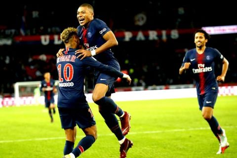PSG's Kylian Mbappe celebrates with his teammate PSG's Neymar after scoring his side's fifth goal during the French League One soccer match between Paris-Saint-Germain and Lyon at the Parc des Princes stadium in Paris, France, Sunday, Oct. 7, 2018. (AP Photo/Michel Euler)