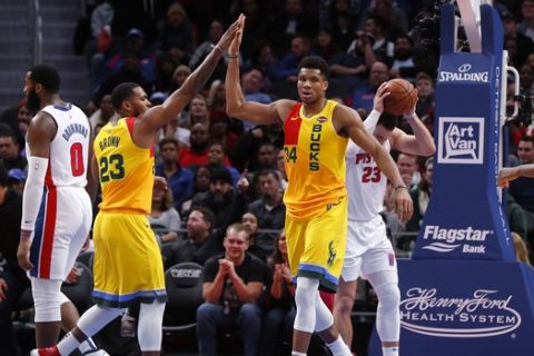 Milwaukee Bucks forward Giannis Antetokounmpo (34) celebrates a basket with Sterling Brown (23) in the second half of an NBA basketball game against the Detroit Pistons in Detroit, Monday, Dec. 17, 2018. (AP Photo/Paul Sancya)