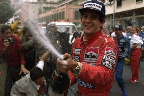 Brazilian driver Ayrton Senna sprays champagne on the photographers to celebrate his career's 30th victory at the Monaco Formula One Grand Prix May 12, 1990.  Britain's Nigel Mansell, who placed second, is visible at right.  (AP Photo/Lionel Cironneau)