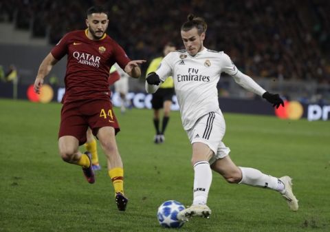 Real midfielder Gareth Bale, right, runs with the ball as he is followed by Roma defender Kostas Manolas during a Champions League, Group G soccer match between Roma and Real Madrid at the Rome Olympic stadium, Tuesday, Nov. 27, 2018. (AP Photo/Andrew Medichini)
