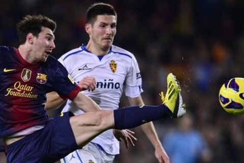 FC Barcelona's Lionel Messi, left, from Argentina duels for the ball against Zaragoza's Adam Pinter during a Spanish La Liga soccer match a at the Camp Nou stadium in Barcelona, Spain, Saturday, Nov. 17, 2012. (AP Photo/Manu Fernandez)